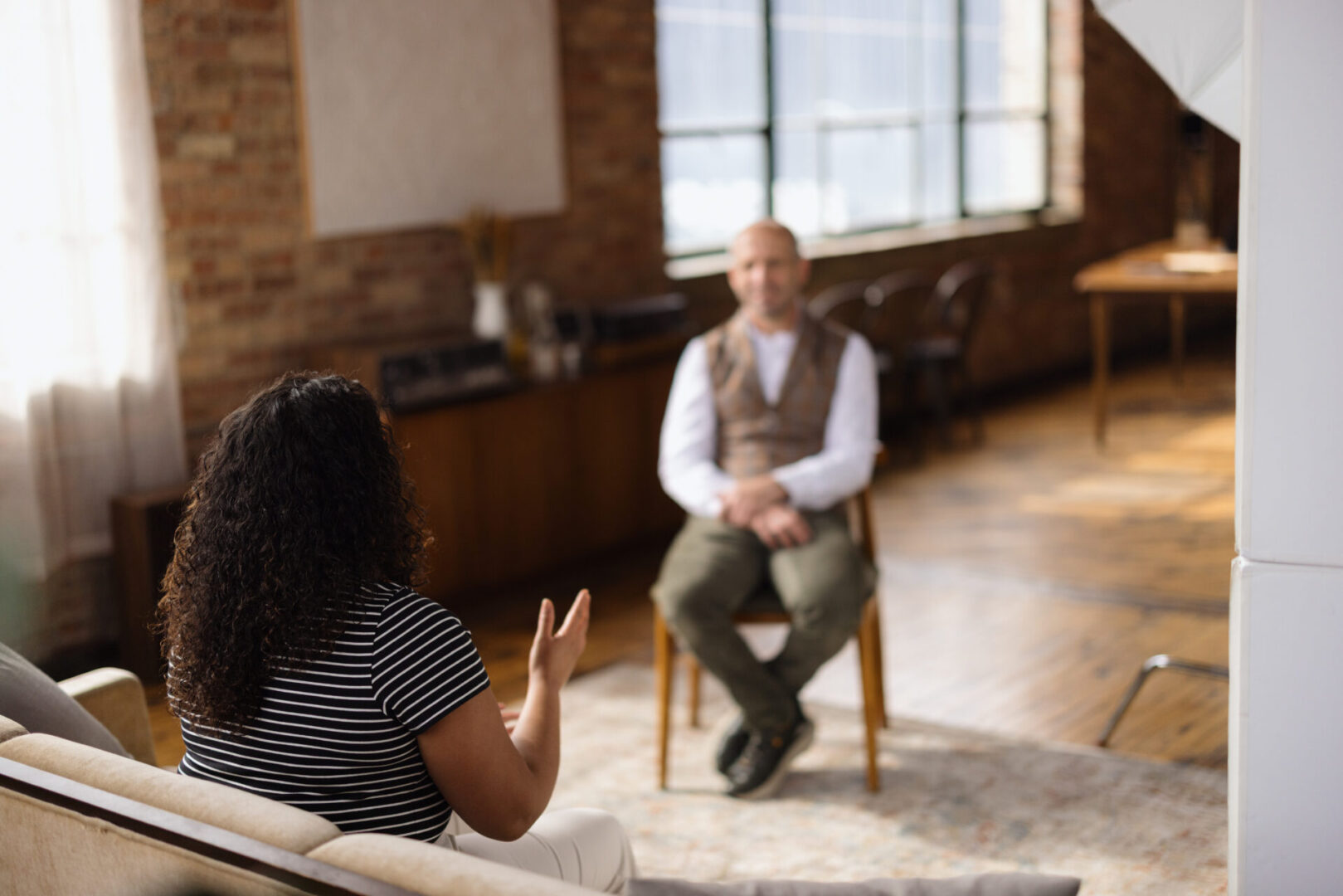 Woman engaging in conversation with a therapist during a therapy session in a contemporary office, fostering communication and support